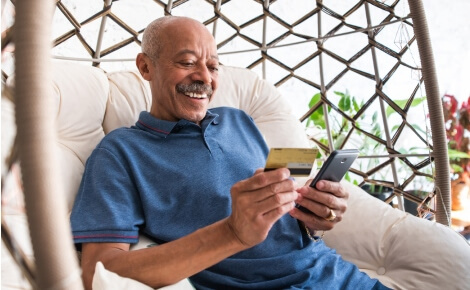 man looking at smartphone and credit card