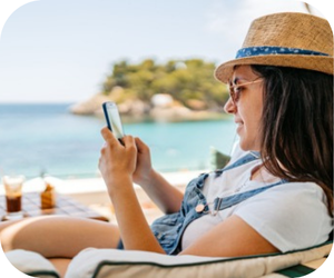 Women on beach vacation using phone