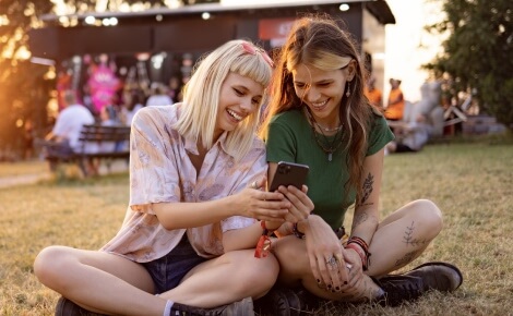 two young women looking at a smartphone