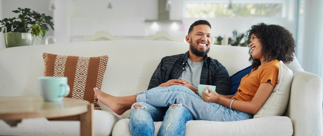 happy couple on couch, sipping coffee, relazed